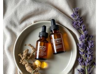 Auswahl an natuerlichen Schlafhilfen wie Melatonin, Baldrian und CBD-Öl in kleinen Flaschen und Kapseln.